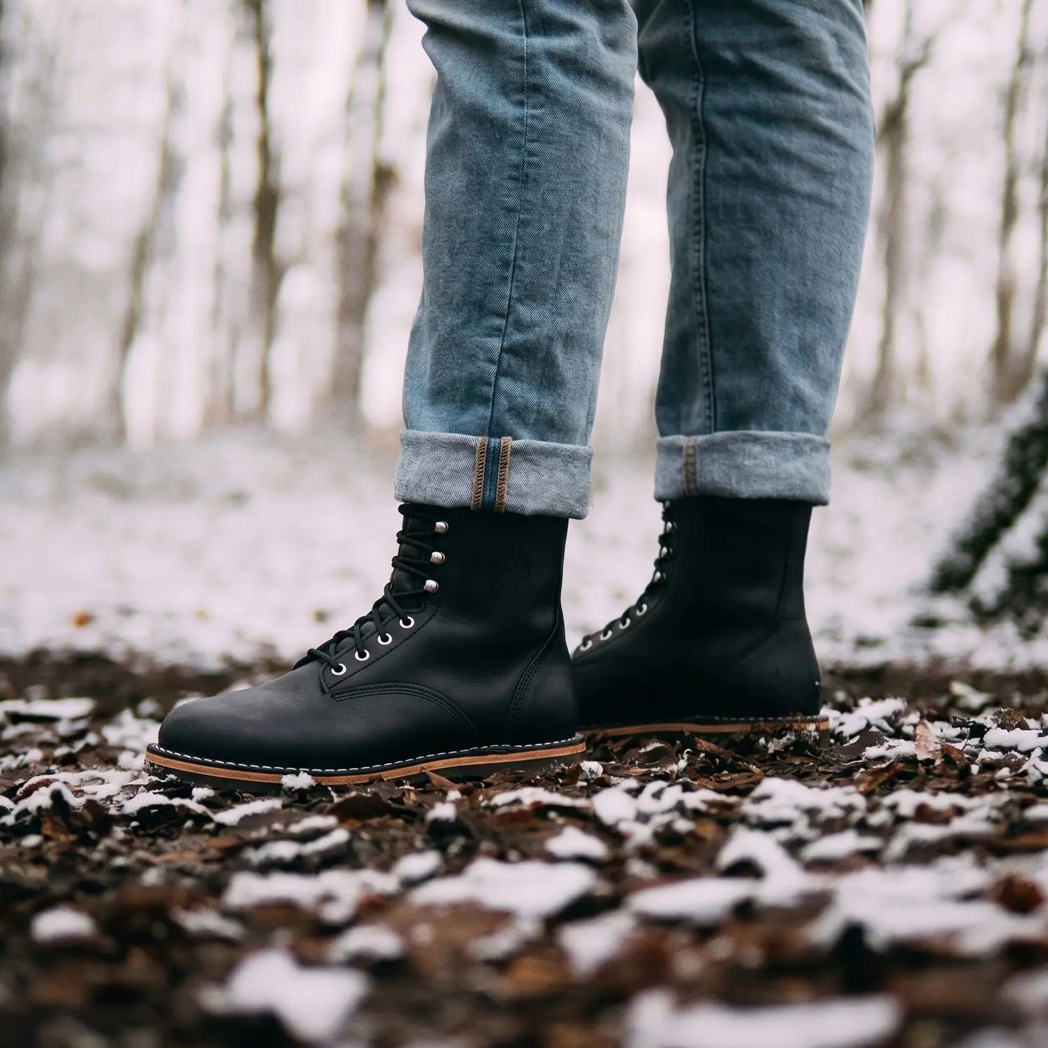 Arktos dark horse black leather lace-up winter-ready barefoot boot with tan soles and silver eyelets featuring merino wool