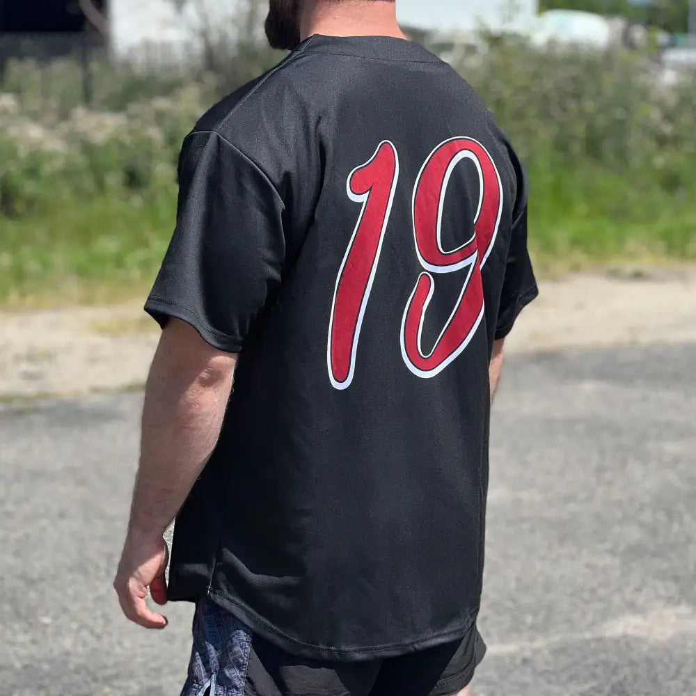 Back of black polyester baseball jersey with bold red 19 outlined in white
