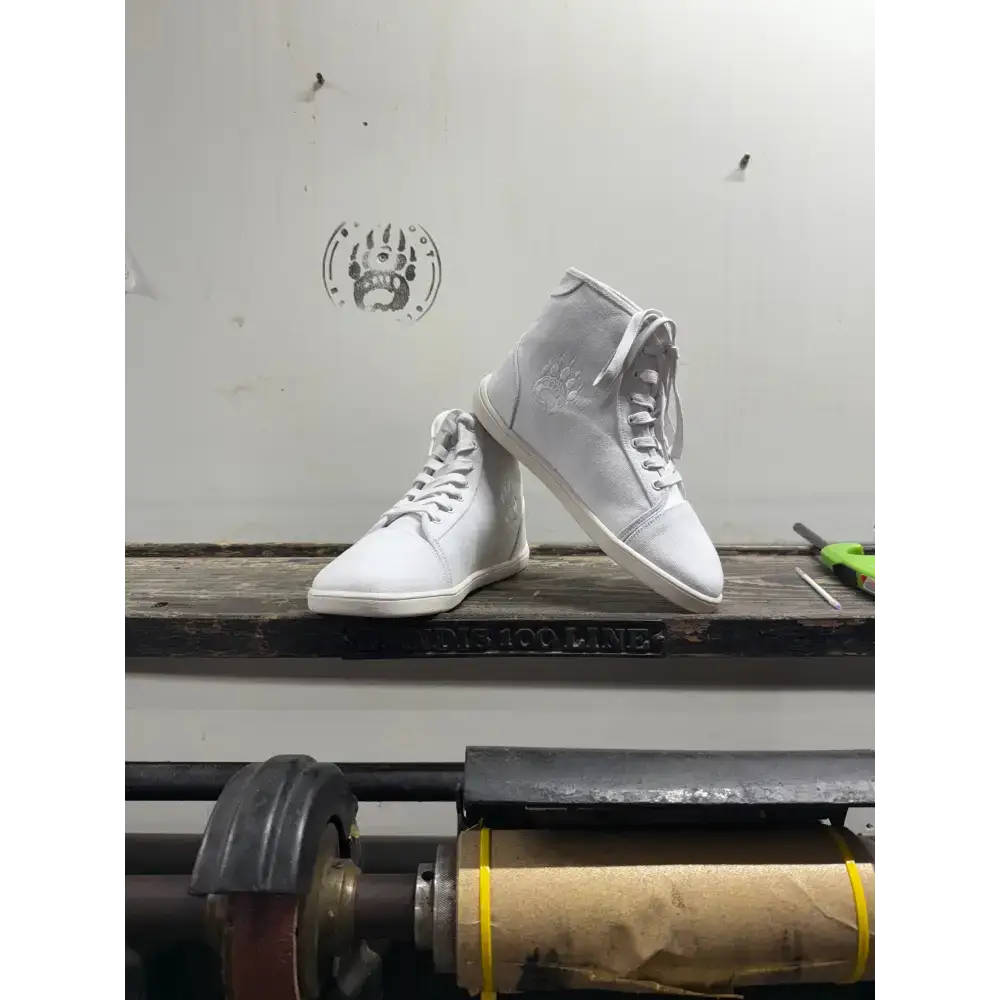 White high-top sneakers with laces, subtle logo from Barely Used Footwear, minor imperfections