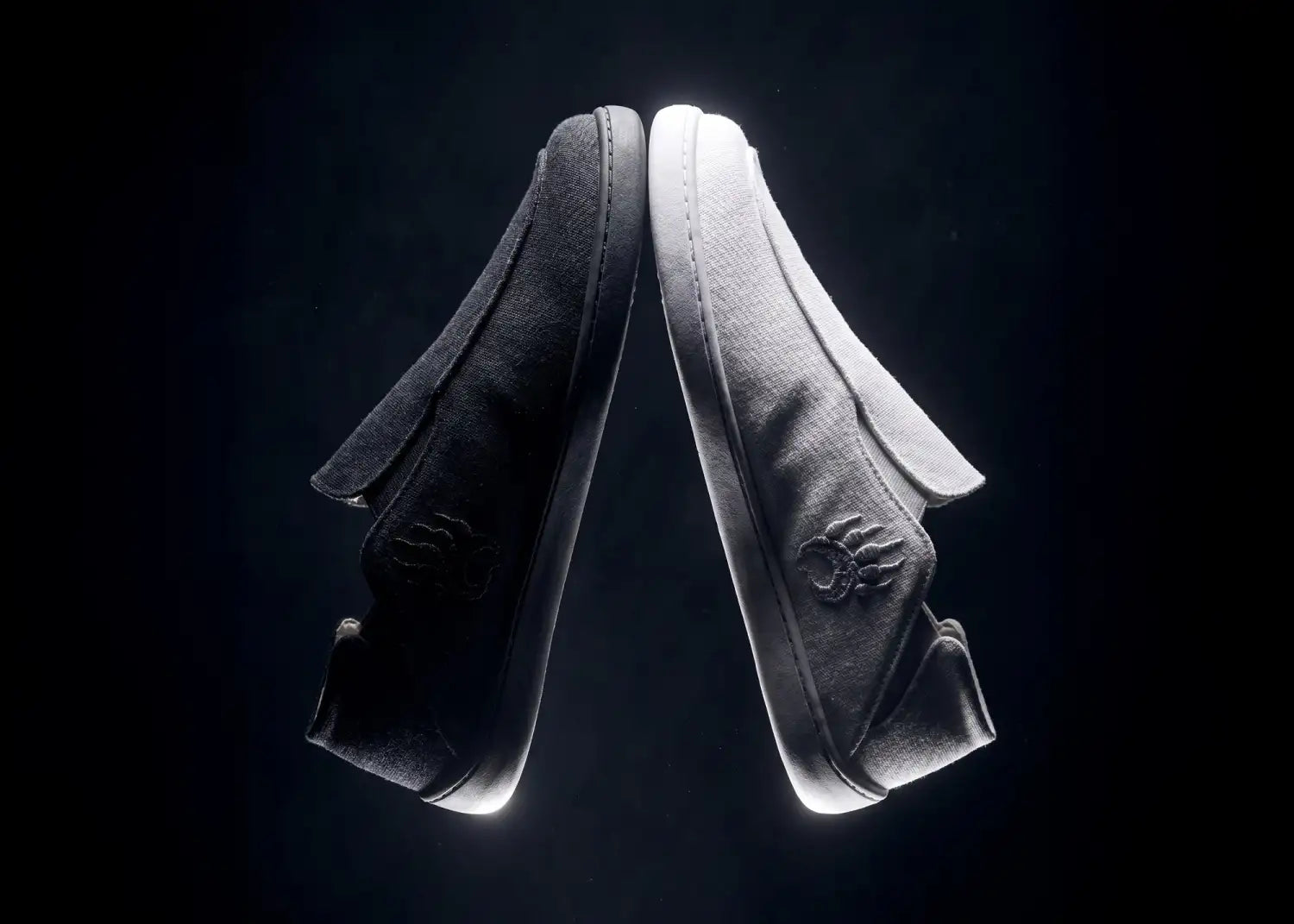 Black canvas slip-on sneakers with a subtle embroidered logo on the side.