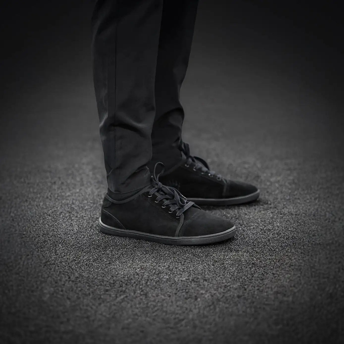 Black suede mid-top sneaker with laces and rubber sole.