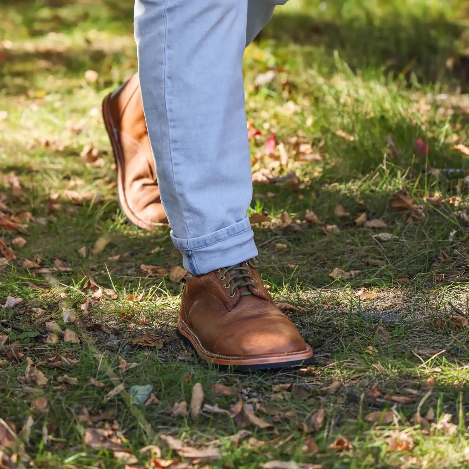 Brown leather lace-up boots with a classic design and dark green laces.