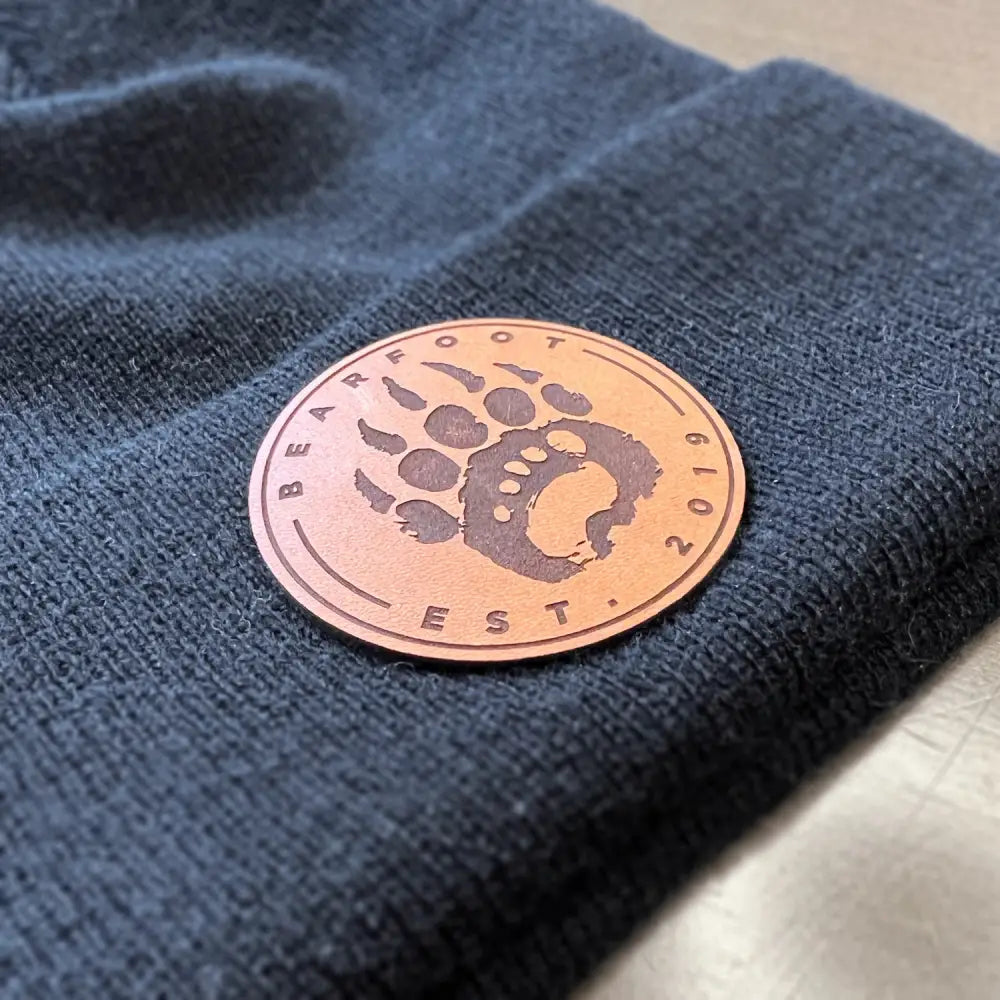 Leather patch beanie with bear paw design and copper accent