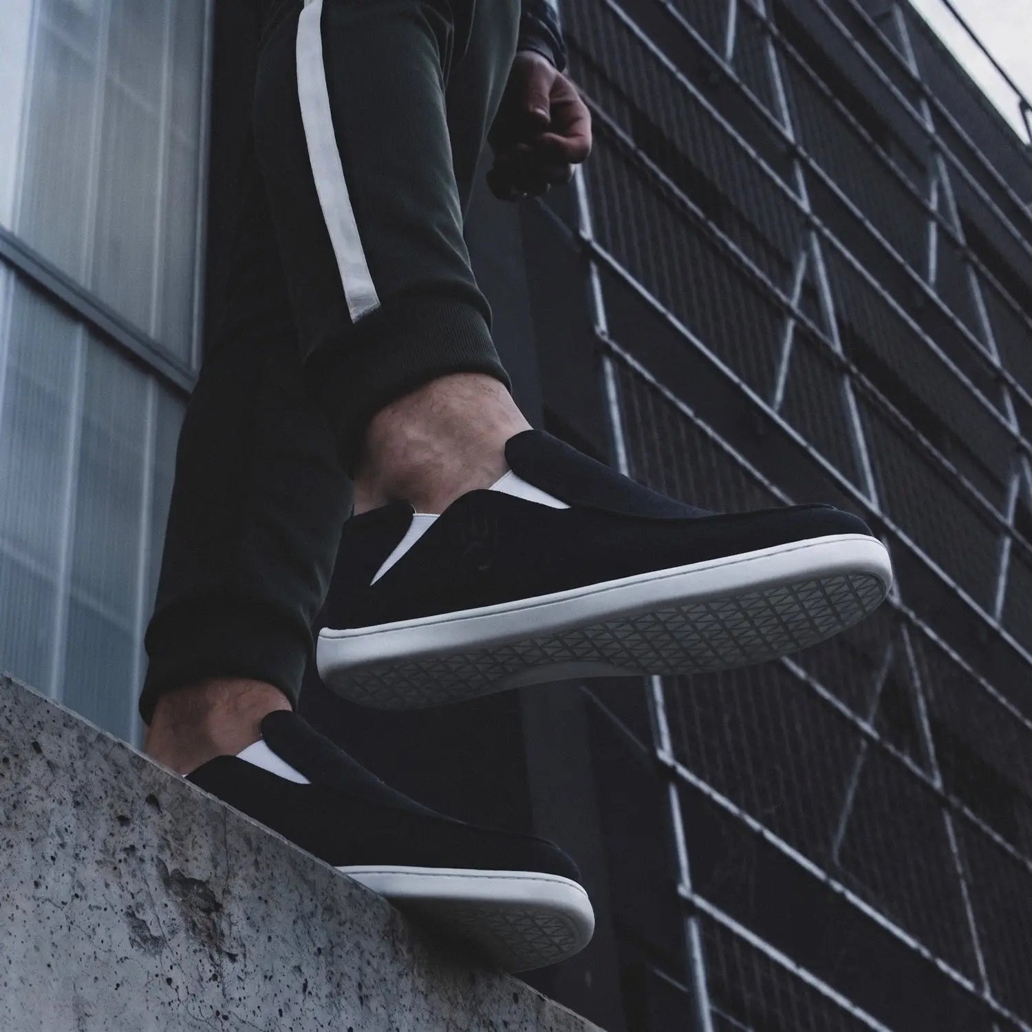 Oso cg2 black barefoot slip-on shoe in black suede with white rubber soles and a wide toe box with white stripe
