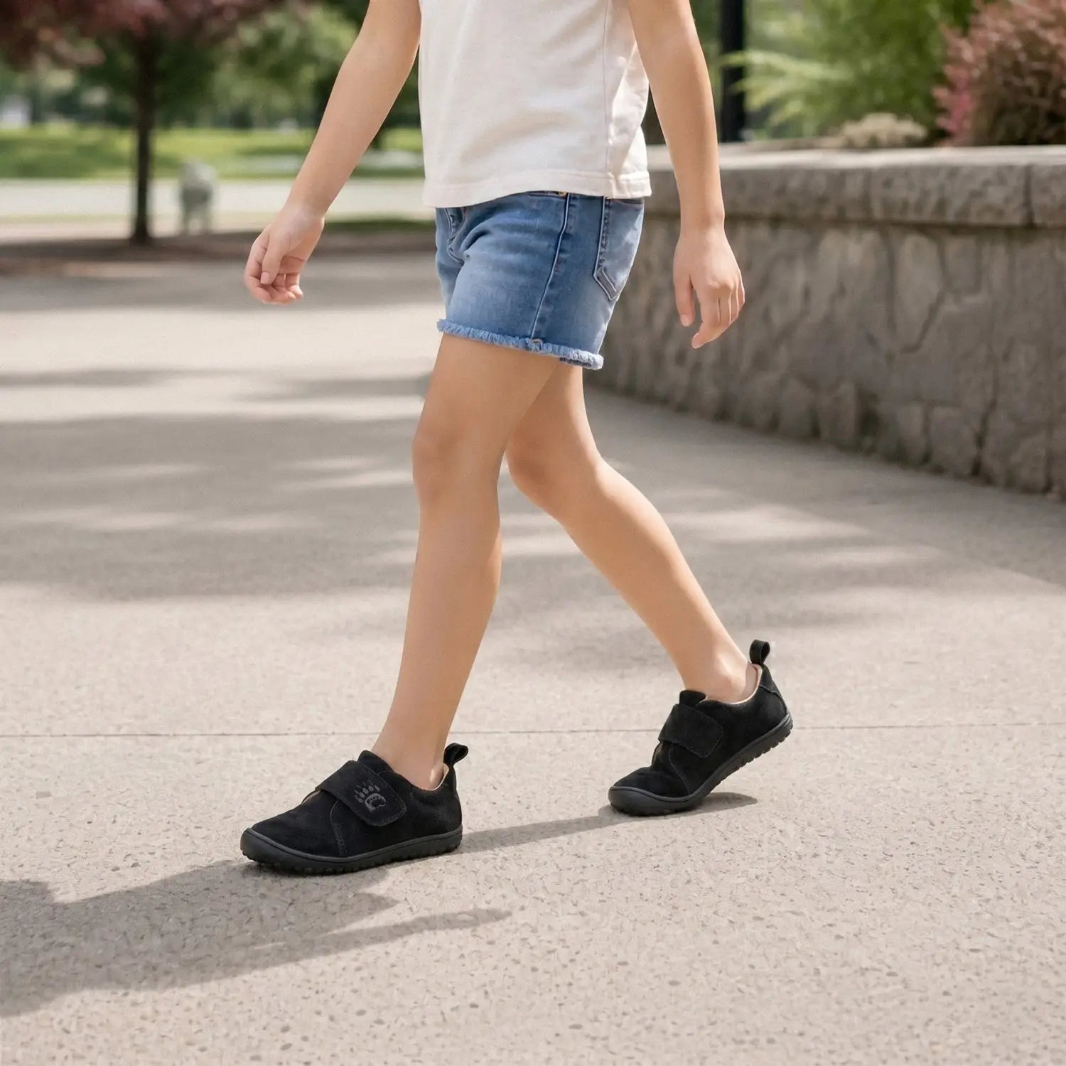 Ursa black slip-on shoes with velcro strap and small logo featuring a wide toe box for comfortable wear