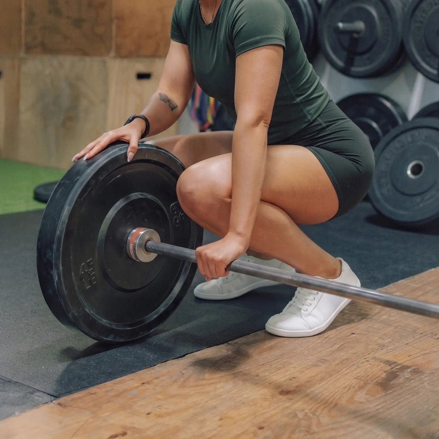 Black weight plate with silver center and red accent on barbell for ursus cltg2 arctic barefoot shoe strength training