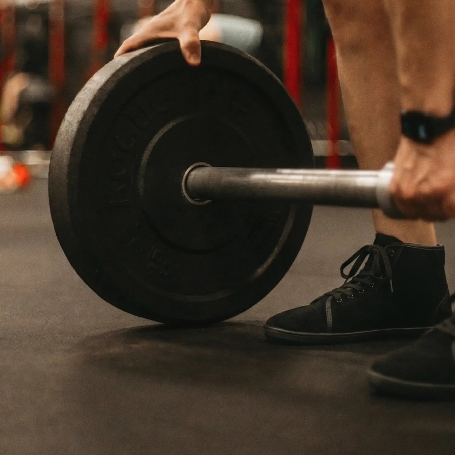 Ursus shtg2 black rubber weight plate on a barbell designed for barefoot shoe users with a wide toe-box fit