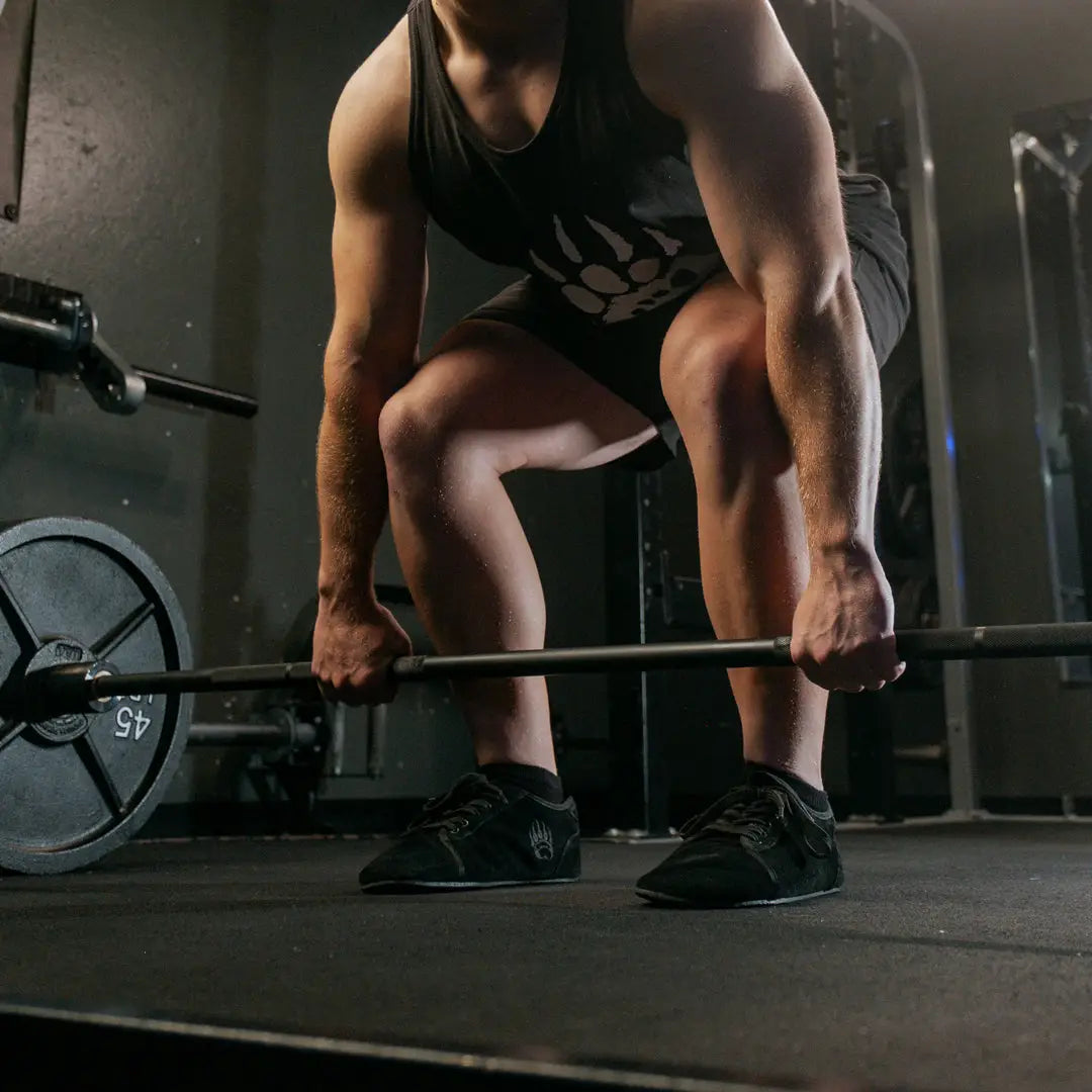 Ursus sltg1 black weightlifting barbell with a 45-pound plate designed for barefoot shoe users with zero-drop sole